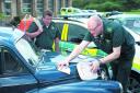 Ambulance responders David England, left, and Dick Tracey give one of their Morris Minors a health check