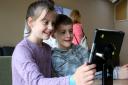 Twins Eva and Harry Wawrzyniak, nine, play on a tablet at Charlbury's new £2.5m community centre on Saturday. Picture: Ric Mellis
