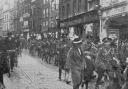A soldier from The Queen’s Own Oxfordshire Hussars says goodbye to his wife and son in Queen Street in 1915