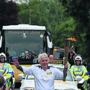 Grandmother Mo Merchant carries the Olympic torch through Nettlebed