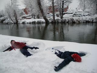 Sarah Lloyd, 10, left, and her brother Patrick Lloyd, 5, right, make snow angels on the banks of the Thames.  Pic: Jessica Mann