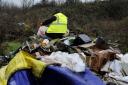 A council environmental health officer wades through a pile of rubbish near Headington (file image)