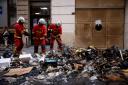 Firemen with the remains of a rubbish fire in Paris (Thomas Padilla/AP)