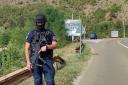 A Kosovo police officer guards the road near the village of Banjska (AP Photo/Dejan Simicevic)