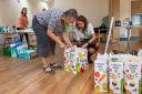 Barratt Homes Sales Adviser Sarah Bennett wrapping food parcels with Helen
