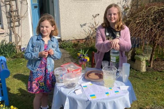 Bicester Advertiser: Christina and her little sister Hayley at their stall raising money for Newsquest's Ukraine appeal.