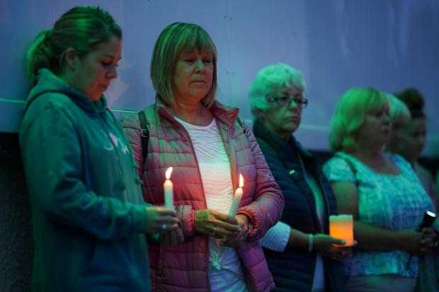 Members of the public hold candles while attending a vigil for the community in Plymouth, Devon, where five people were killed by gunman Jake Davison