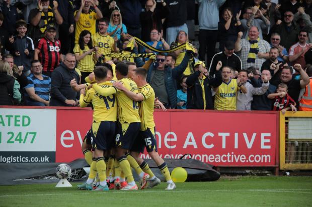 Oxford United players celebrate in front of the away support
