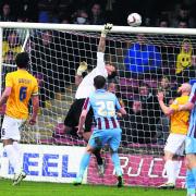 Ryan Clarke tips the ball over the bar – just one of several fine stops he made against Scunthorpe